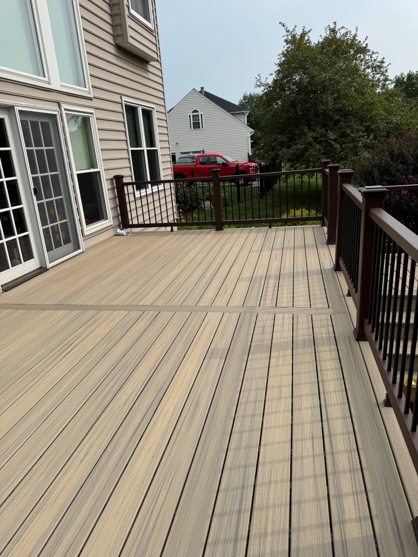 Finished tan composite deck with brown railing after replacement